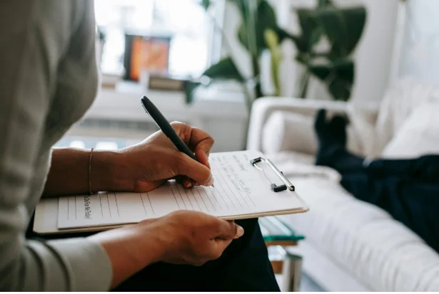 Persona tomando notas en una hoja de diagnóstico inicial, representando el primer paso en el proceso de trabajo de Ozado Business Consulting para entender las necesidades del cliente.